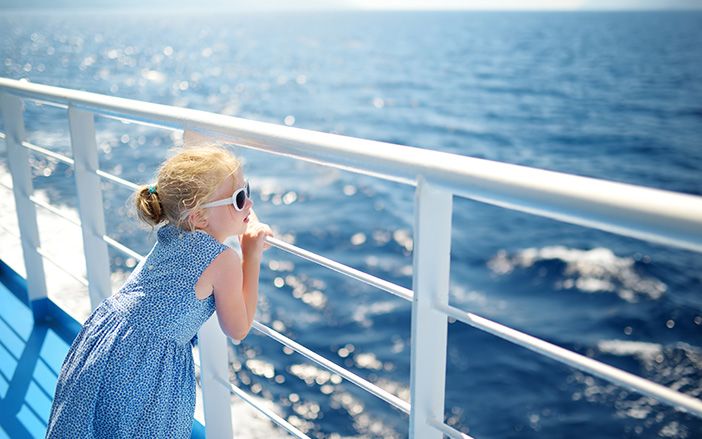Little girl gazing the sea from the ship