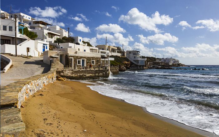 Sikinos beach with the view of small, white houses